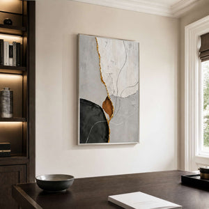 Silver framed abstract artwork in white, gray, and charcoal beside an office bookshelf.