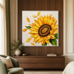 White-framed sunflower artwork above a walnut dresser beside an olive chair and a cream bed.