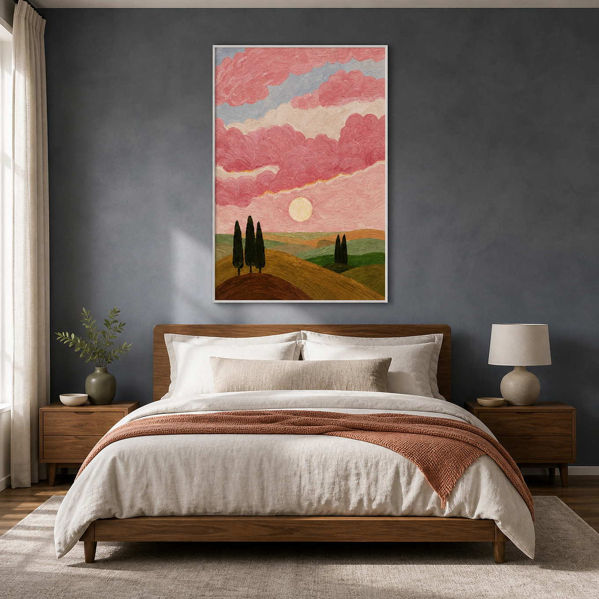 White framed painting of sunlit hills and pink clouds above a bedroom headboard.