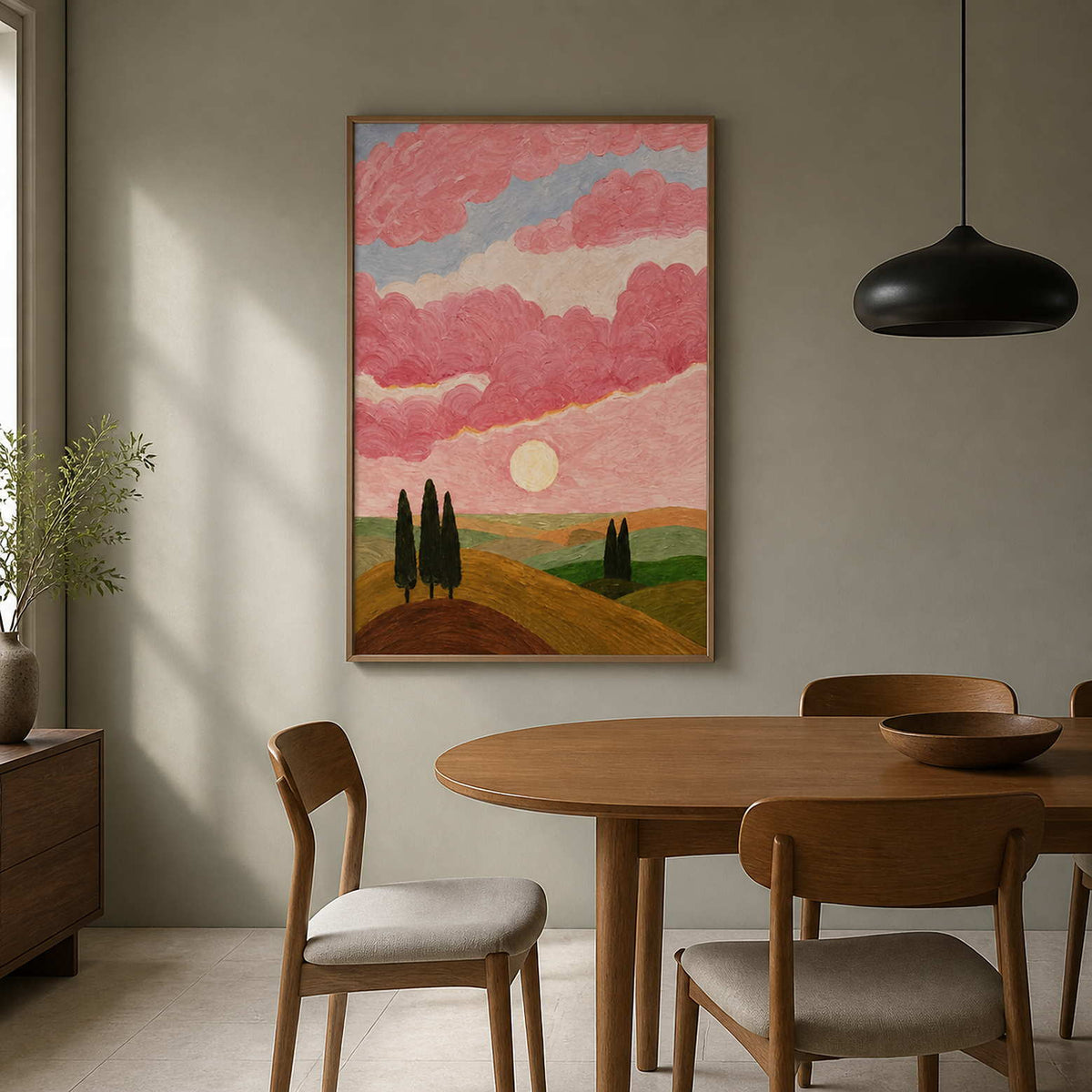 Pink sky landscape in a wood frame beside a wooden dining table.
