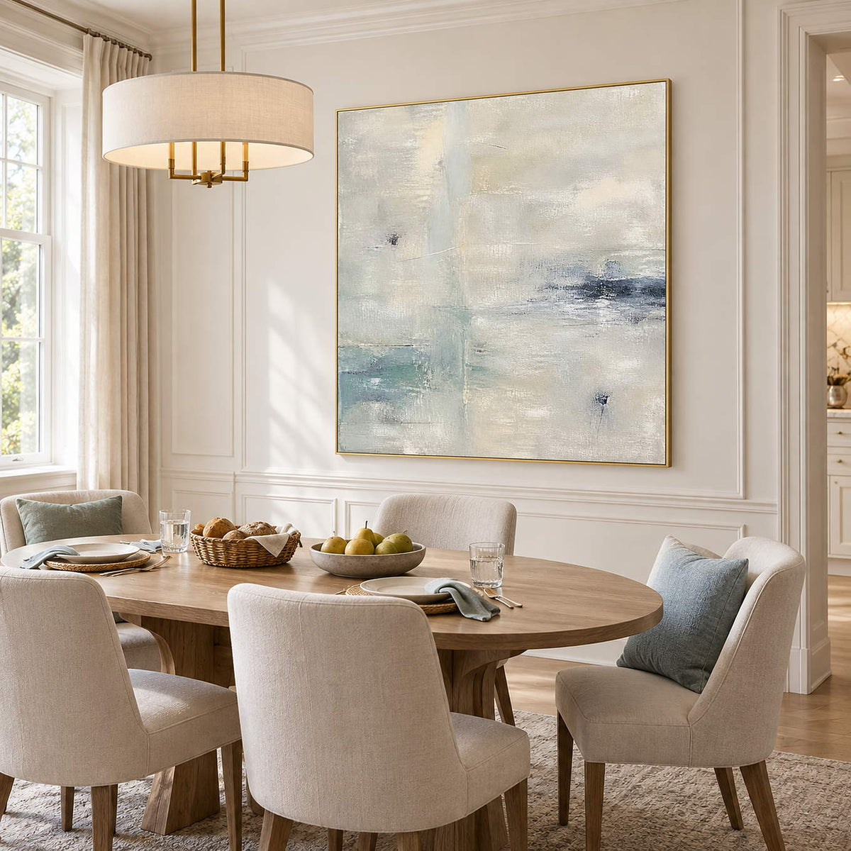 Square neutral abstract painting with ivory, pale aqua, and blue-gray marks in a gold frame in a dining room.