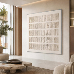 Silver framed cream abstract artwork overlooking a bright hotel lobby seating area.