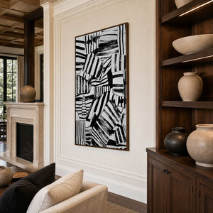 Wood-framed black and white wall art between a fireplace and shelves in a lounge.