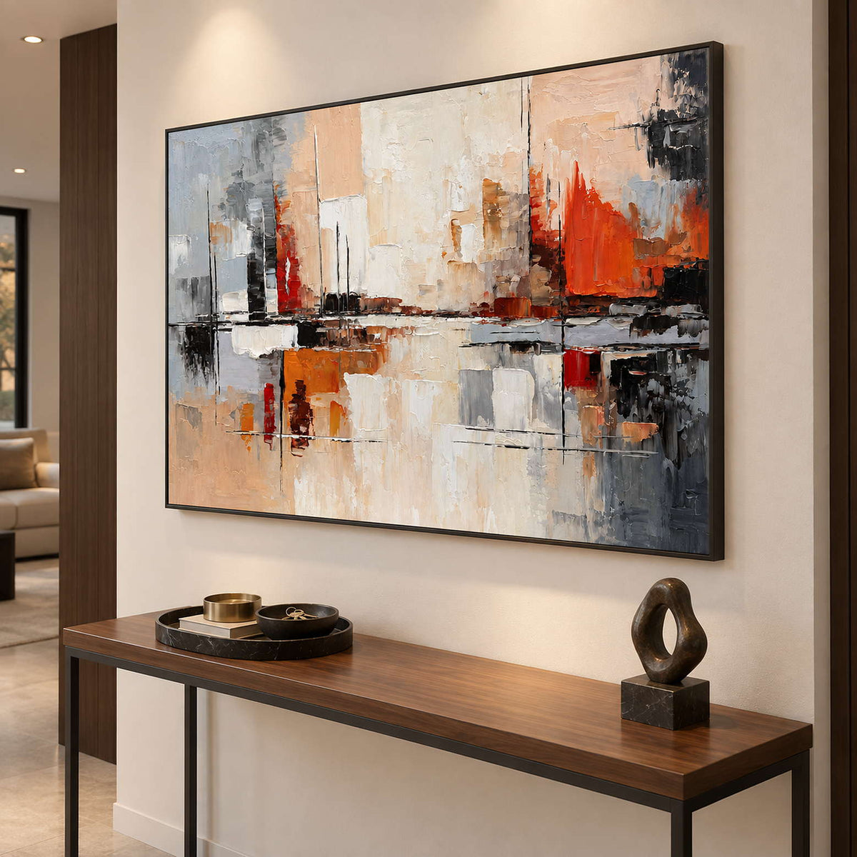 Black-framed abstract painting above a slim wood console with a dark loop sculpture.