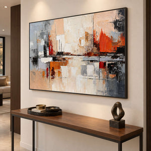 Black-framed abstract painting above a slim wood console with a dark loop sculpture.