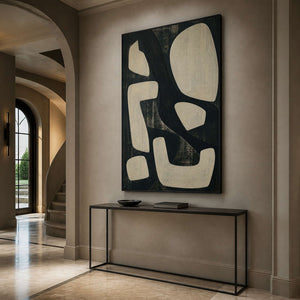 Graphic abstract wall art in an elegant entryway with a black frame.