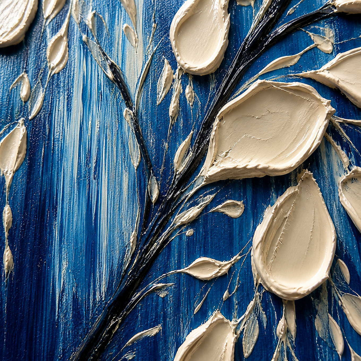 Close-up of sculpted ivory petals, dark branches, and cobalt paint.