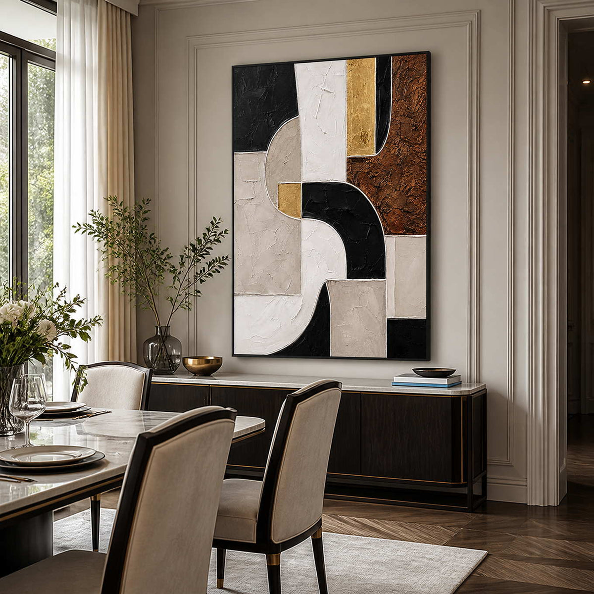 Black framed geometric artwork beside a marble dining table and upholstered cream chairs.