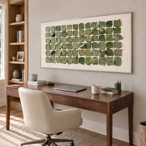 Keeping a Little Spring in a silver frame above a wood desk and cream swivel chair beside tall shelves.