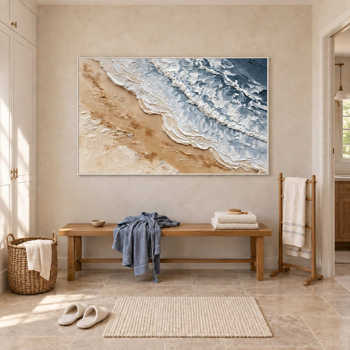 Kissing the Shore in a white frame above a bench with blue and white towels in a bathroom dry area.