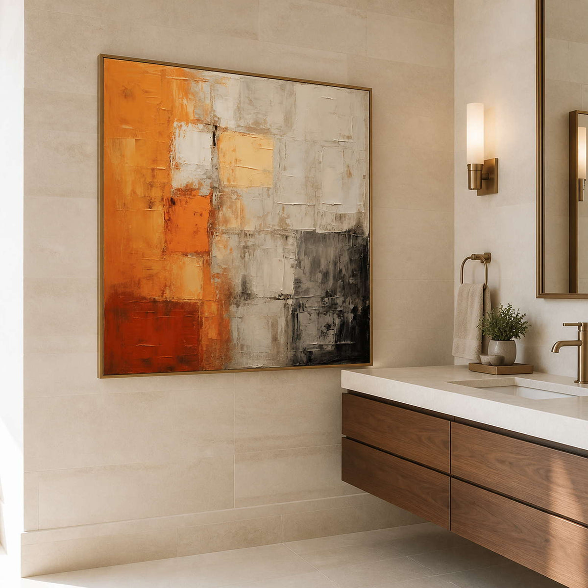 Wood framed orange abstract painting beside a stone vanity in a bathroom.