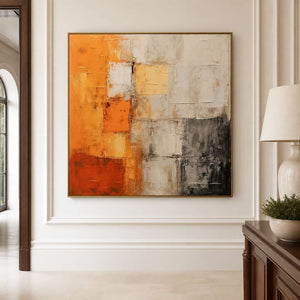 Gold framed textured abstract wall art beside a hallway console and lamp.