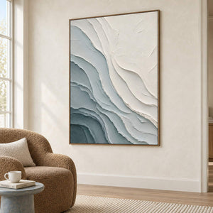 Layered blue-gray and chalk-white coastal relief painting in a brown wood frame in a lounge.
