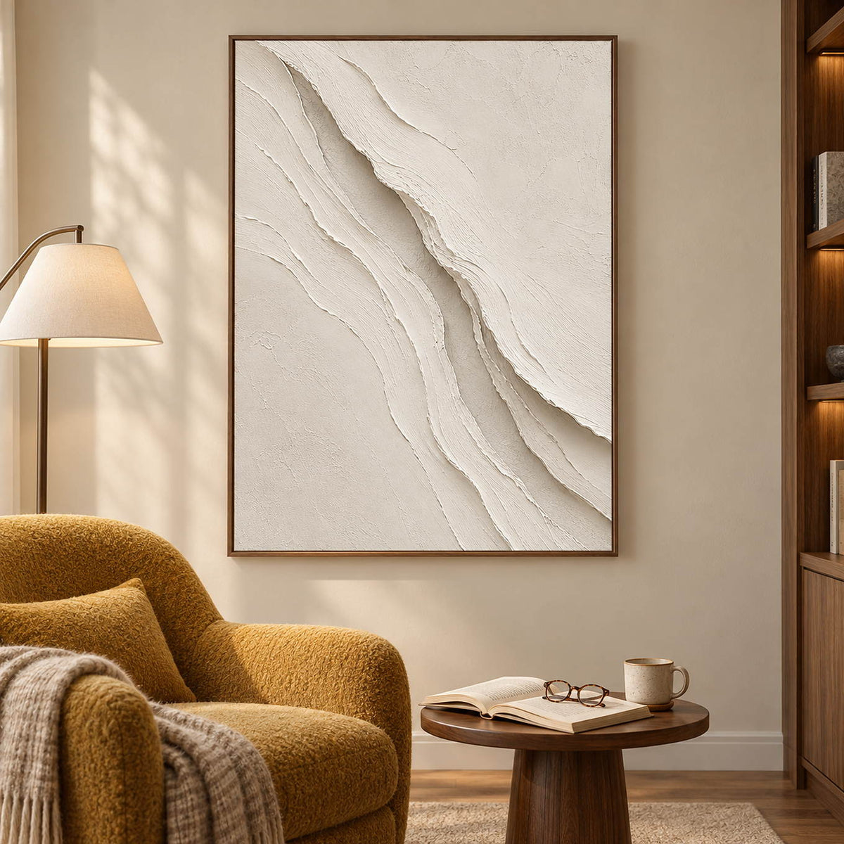 Hand-painted ivory abstract wall art with layered cream palette-knife relief, displayed in a reading room in a brown wood frame.