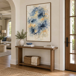 Let Your Thoughts Wander in a wood frame above an entryway console with a ceramic vase and woven basket.