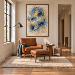 Let Your Thoughts Wander in a wood frame above a caramel leather chair and footstool beside a black reading lamp.