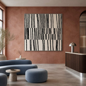 Silver framed black stroke artwork above blue seating in a warm reception area.