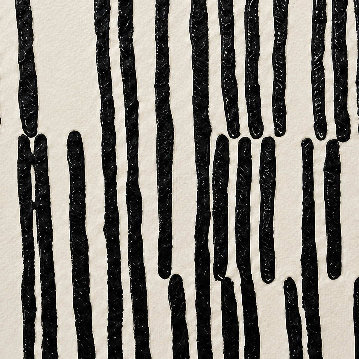 Close detail of raised irregular black marks against a softly textured off-white background.