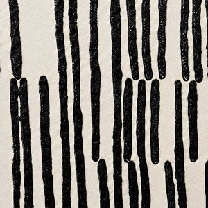 Close detail of raised irregular black marks against a softly textured off-white background.
