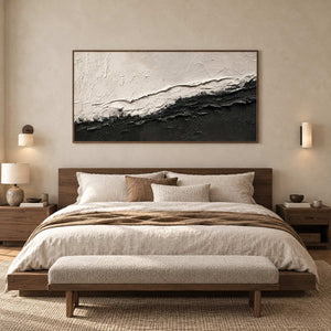 Rough-edged black-and-white abstract above a wooden bed with neutral bedding.
