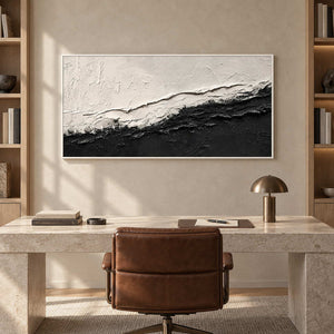 Black-and-white layered artwork above a pale desk and brown swivel chair.