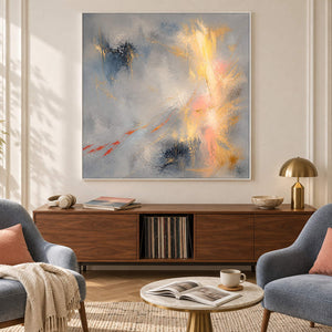 Blue-gray abstract painting with gold, blush, and dark blue marks in a white frame in a lounge.