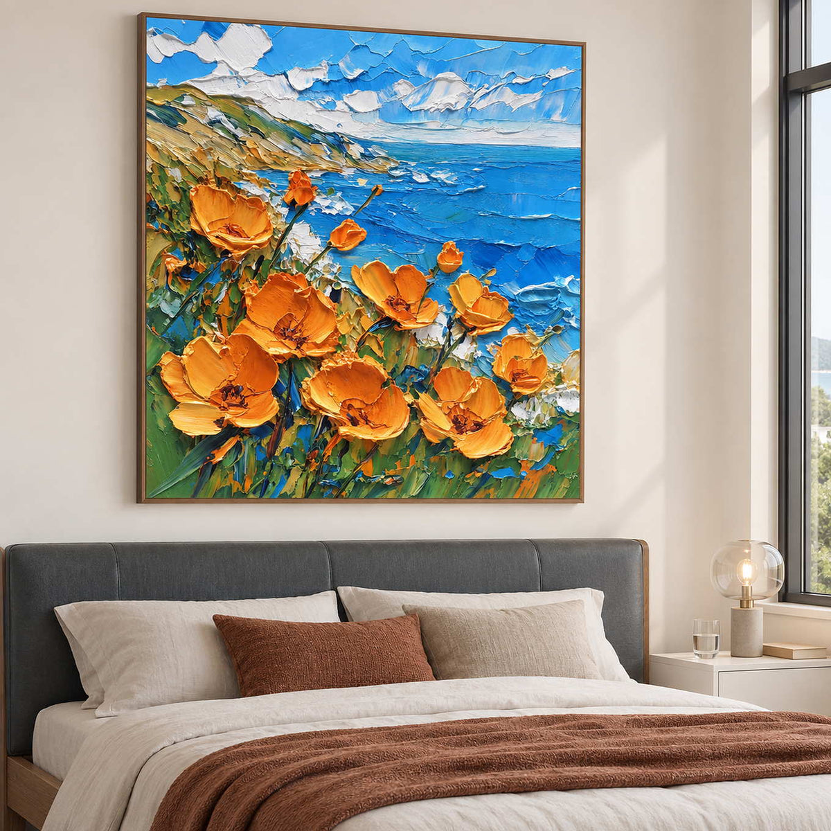Floral coastal artwork above a bed with a rust-colored throw.