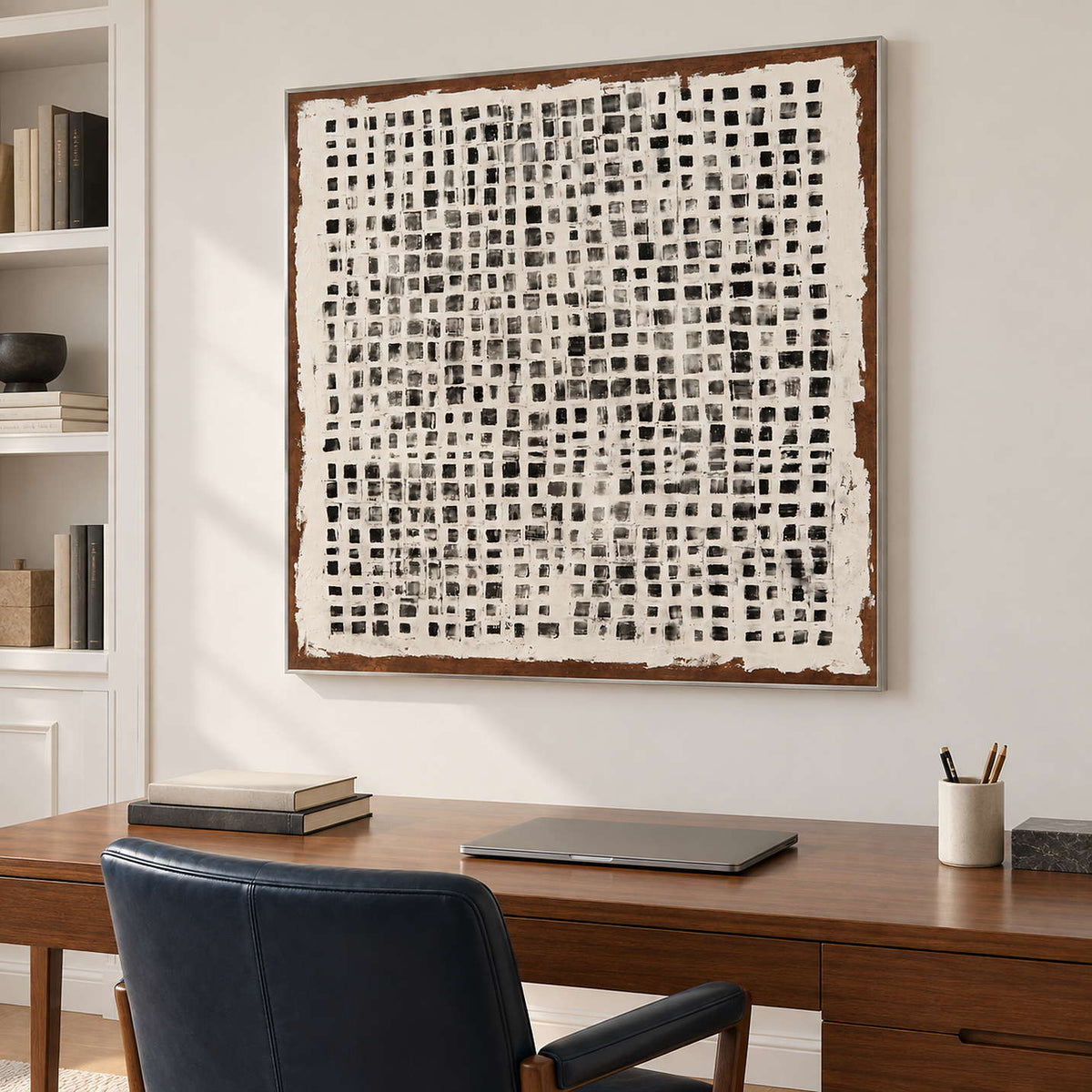 Grid painting above a wooden desk and dark office chair.