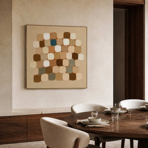 Wood framed earth toned squares beside a dining table set with white dishes.