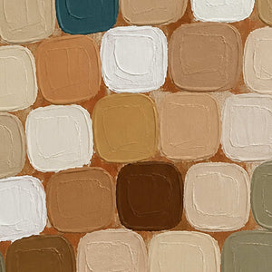 Close view of rounded white, tan and brown painted patches with raised edges.