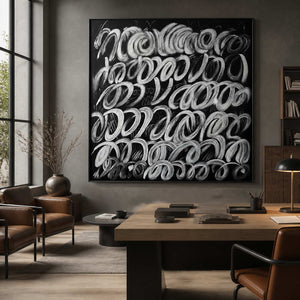Black framed looping abstract painting displayed above a desk in a design studio.