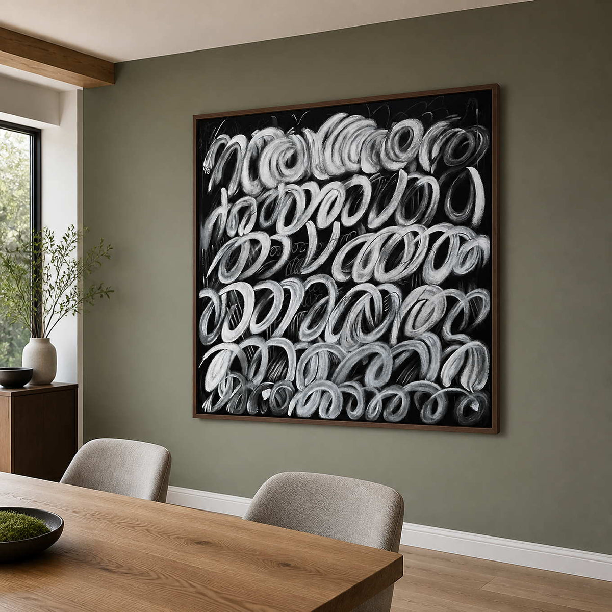 Wood framed monochrome loop painting displayed beside a wooden dining table.