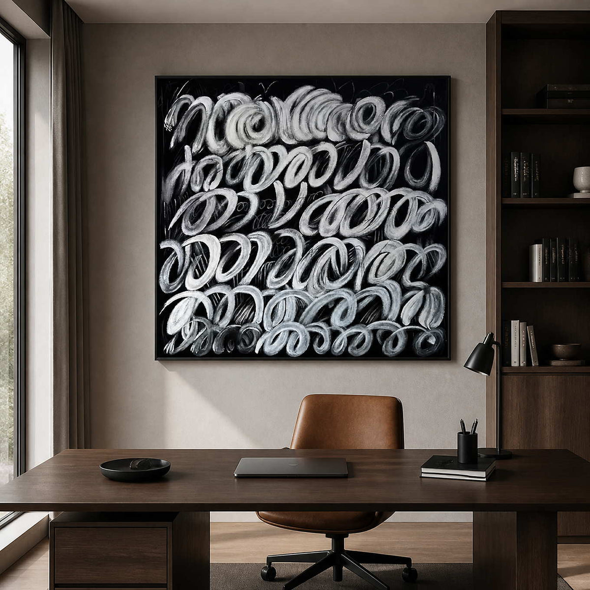 Black framed white loop artwork above a wooden desk in a home study.