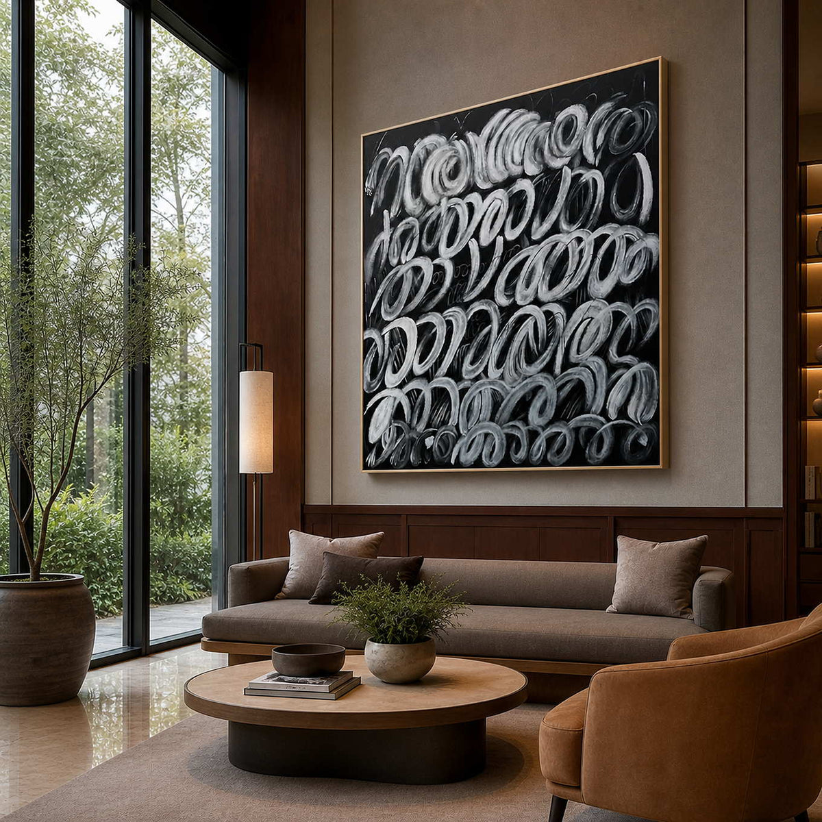 Gold framed white loop painting above lounge seating beside hotel lobby windows.