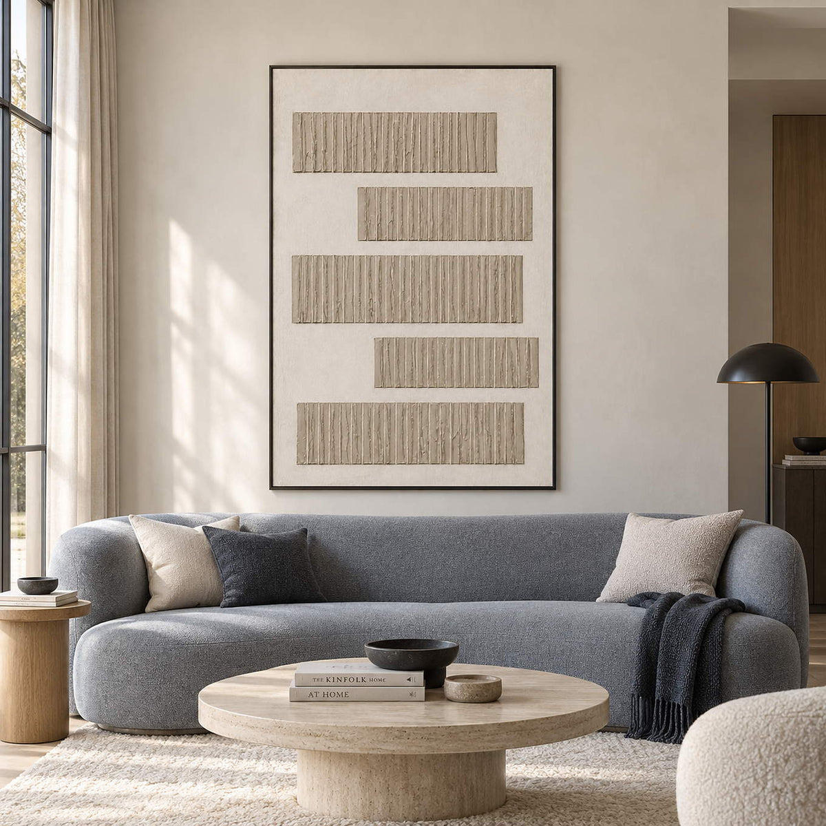 Five hand-built gray-beige relief bands arranged on a warm white canvas, displayed in a living room in a black frame.