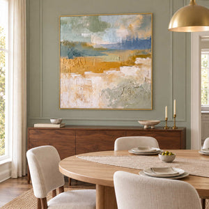 Meeting the Open Country in a gold frame above a dark wood sideboard beside a round dining table against sage paneling.