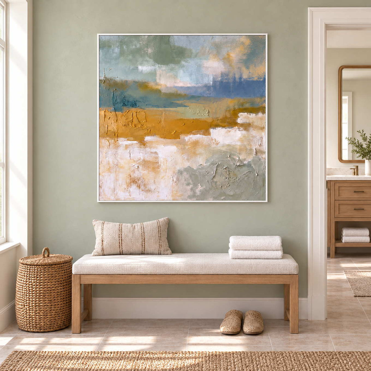 Meeting the Open Country in a white frame above a pale bench with folded towels and a striped cushion beside a bathroom vanity.