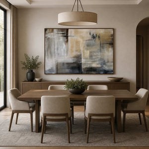 Wood framed misty abstract painting above a sideboard behind a neutral dining table.