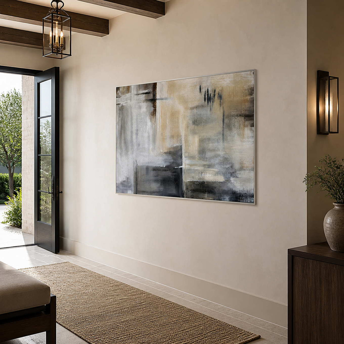Silver framed horizontal abstract artwork beside an open entry door and wood cabinet.