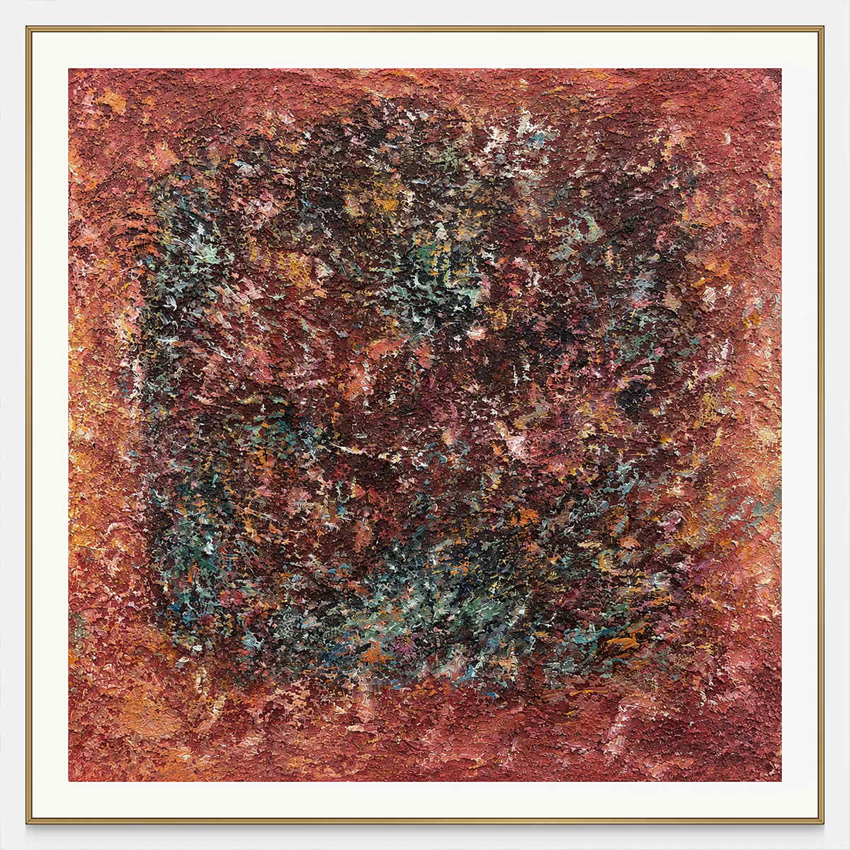 Front view of a dark textured ring surrounded by rust red and orange with scattered turquoise flecks, with a gold-colored frame.