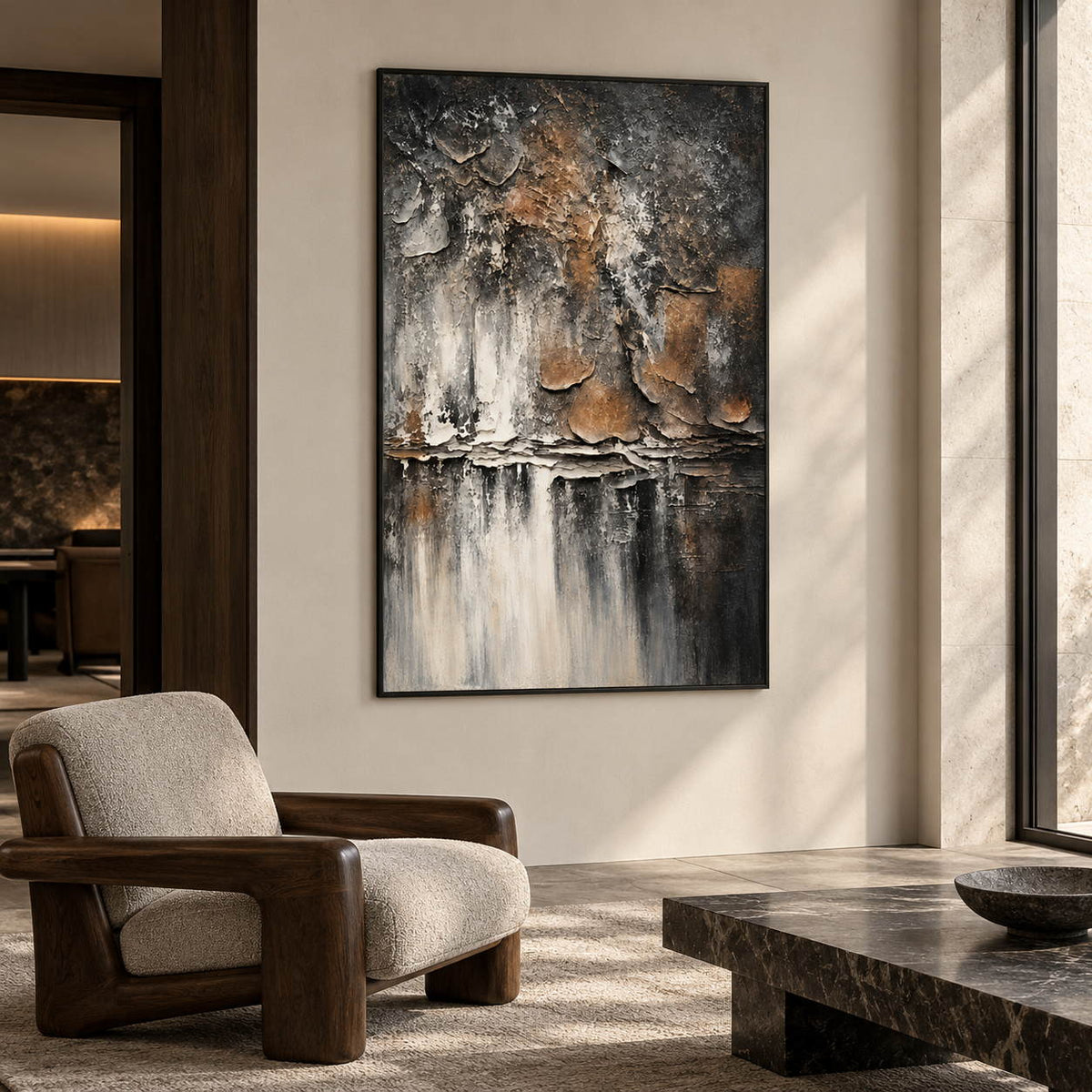Dark gray and brown flaking forms above horizontal strata and pale vertical streaks in an artwork with a black frame, displayed in a lounge with seating.