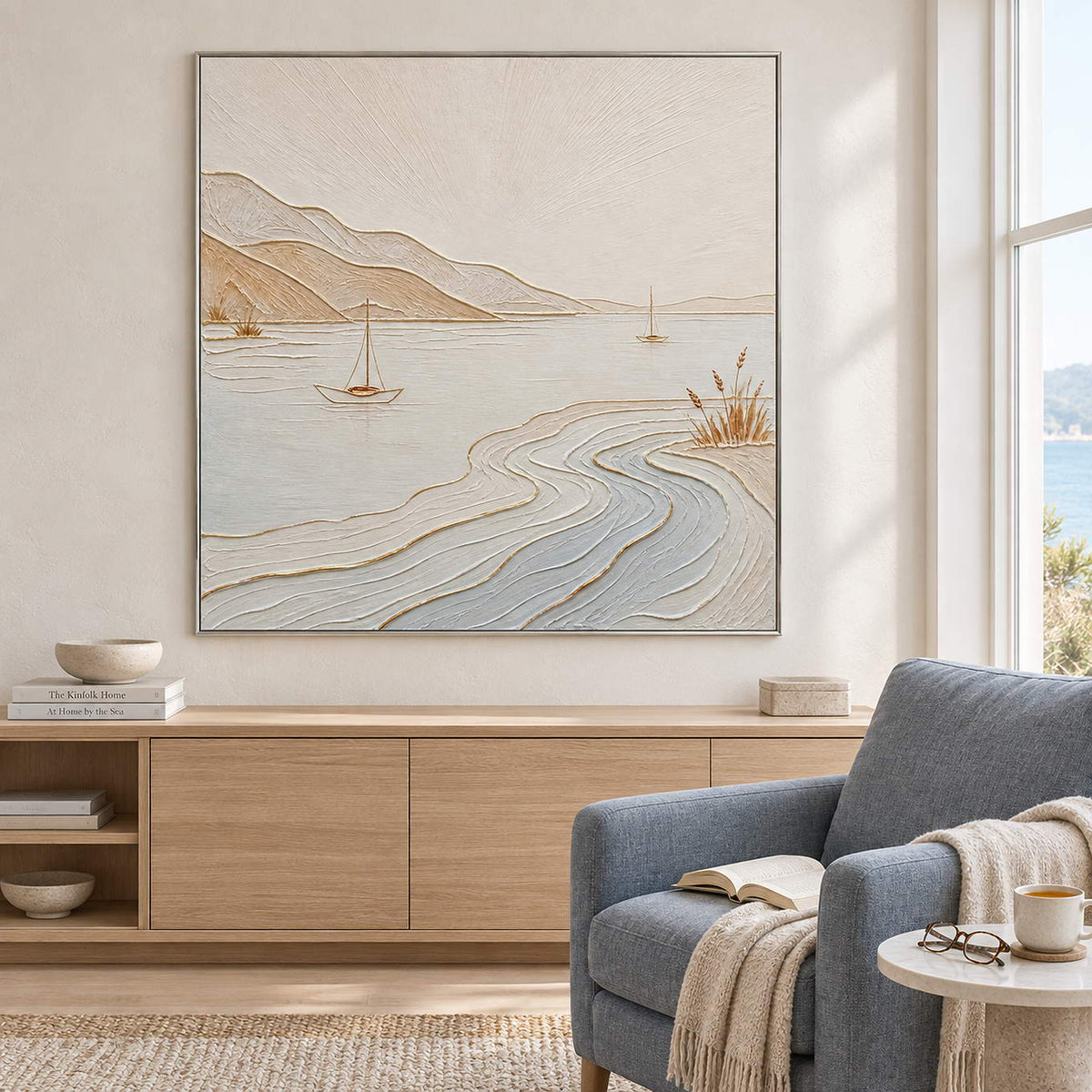 Pale coastal painting with sailboats, sandy hills, and curving wave contours in a silver frame in a reading room.