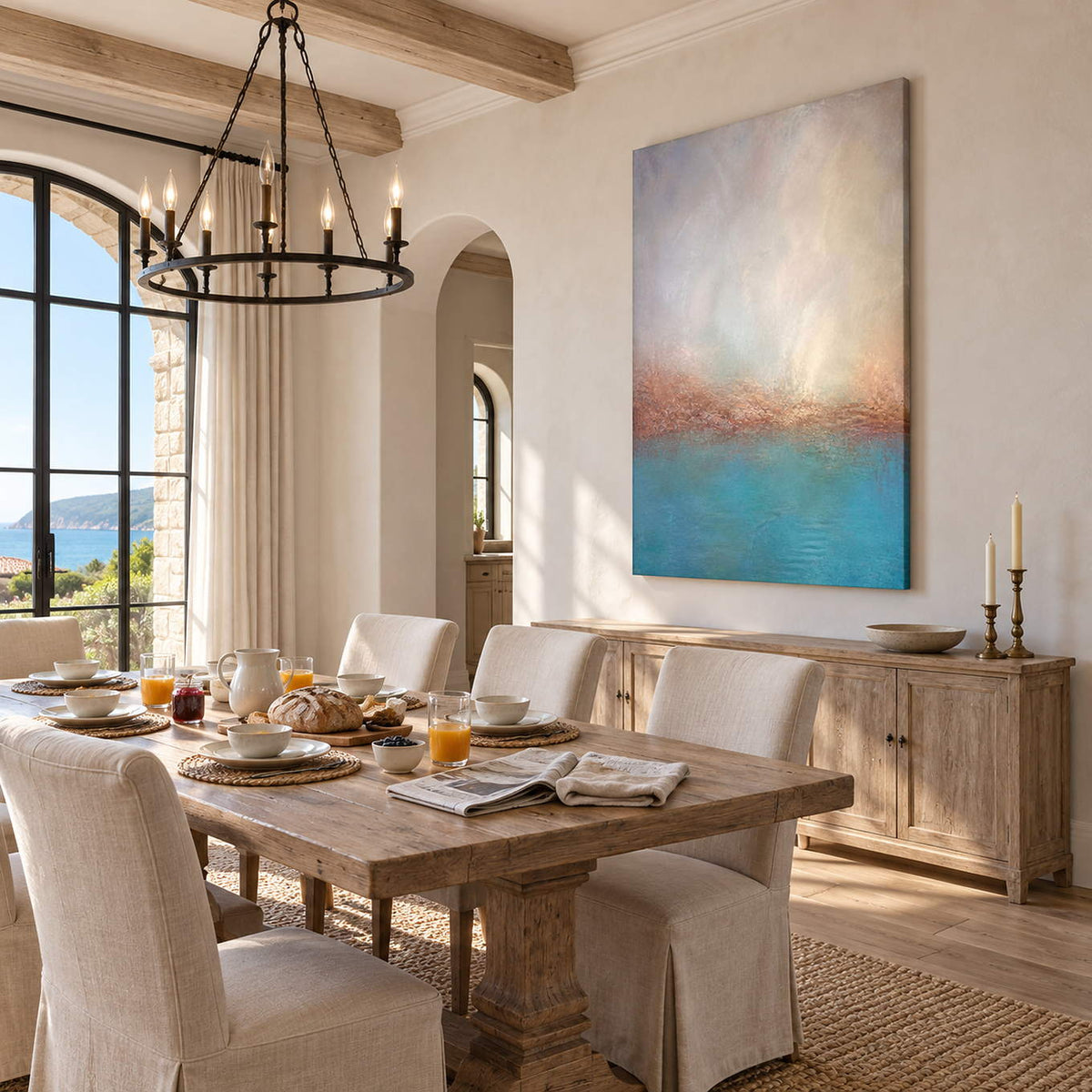 Turquoise coastal painting with a warm shoreline and a luminous pale sky without an outer frame in a dining room.