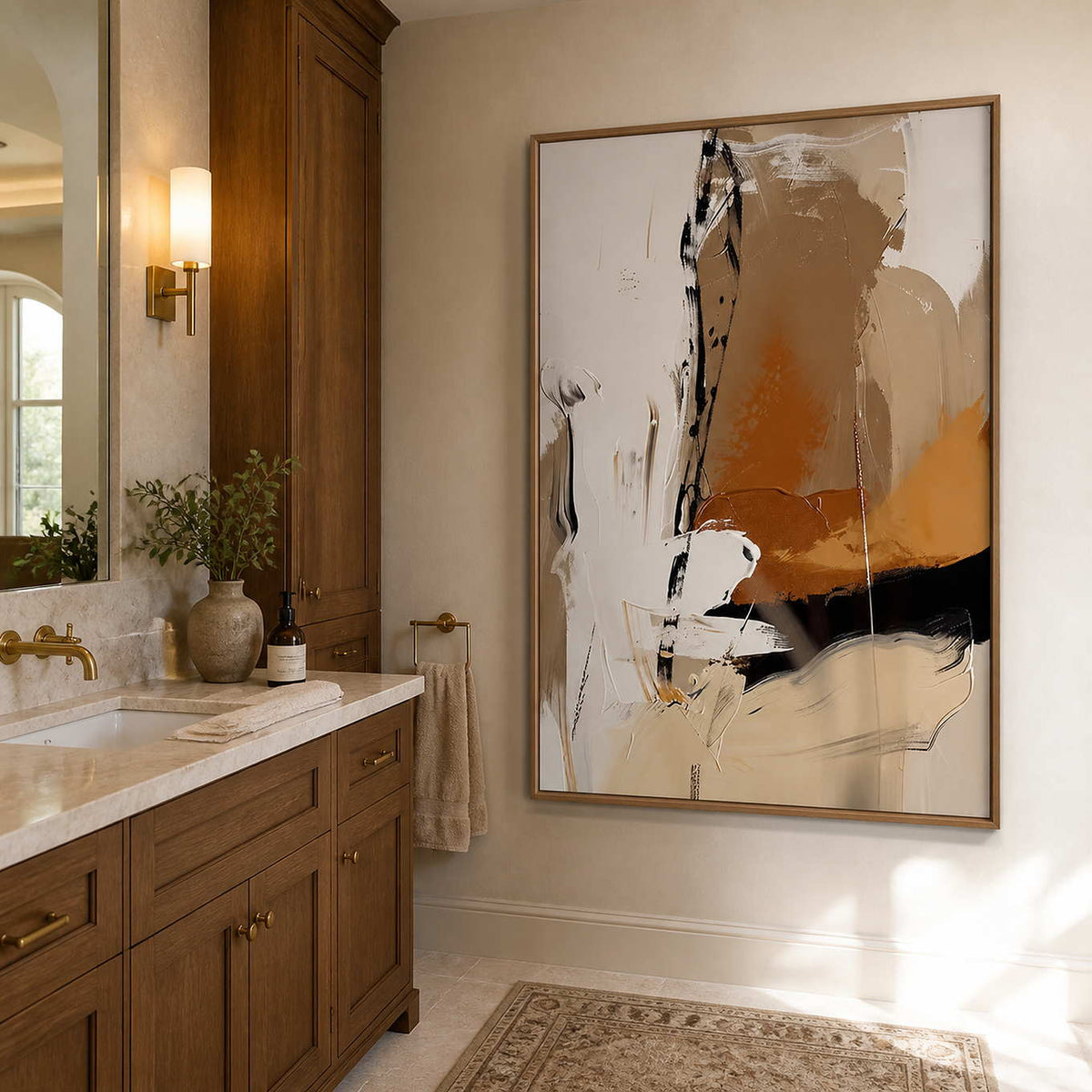 Wood framed warm abstract artwork beside a stone vanity and brass bathroom fixtures.