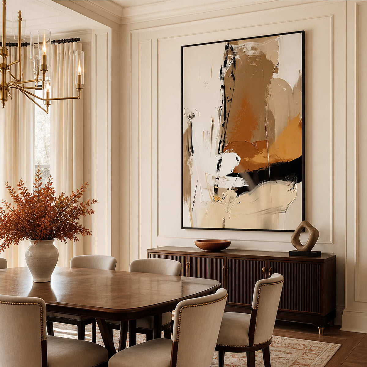 Black framed warm abstract artwork above a sideboard beside a wooden dining table.