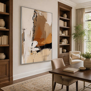 Silver framed gestural abstract artwork beside walnut bookcases and a study table.