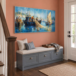 Hand-painted harbor scene with fishermen, sailboats, and luminous blue water, displayed in an entrance hall in a silver frame.