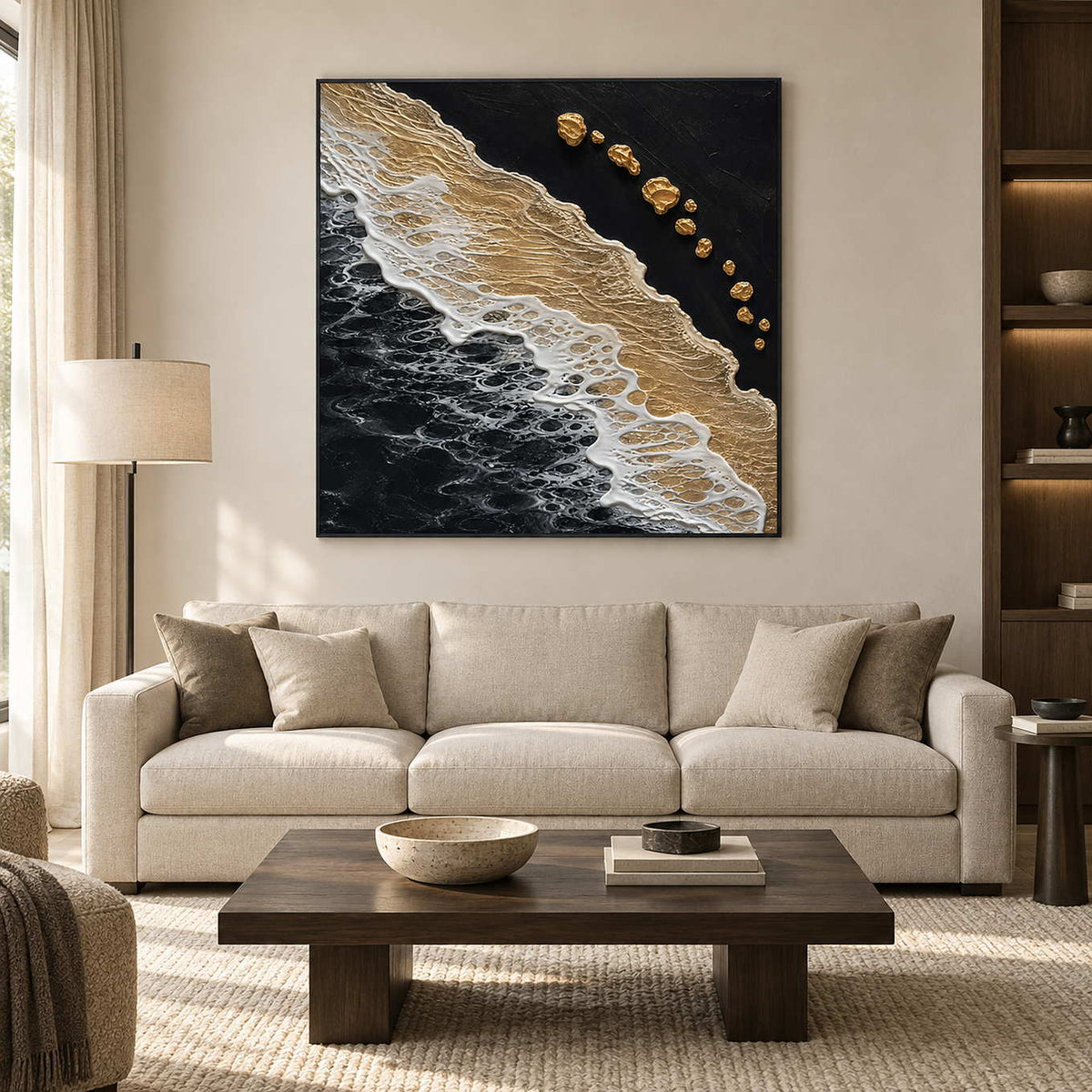 Night Tide in a black frame above a cream sofa, with gold and white textured surf contrasting against a black field.