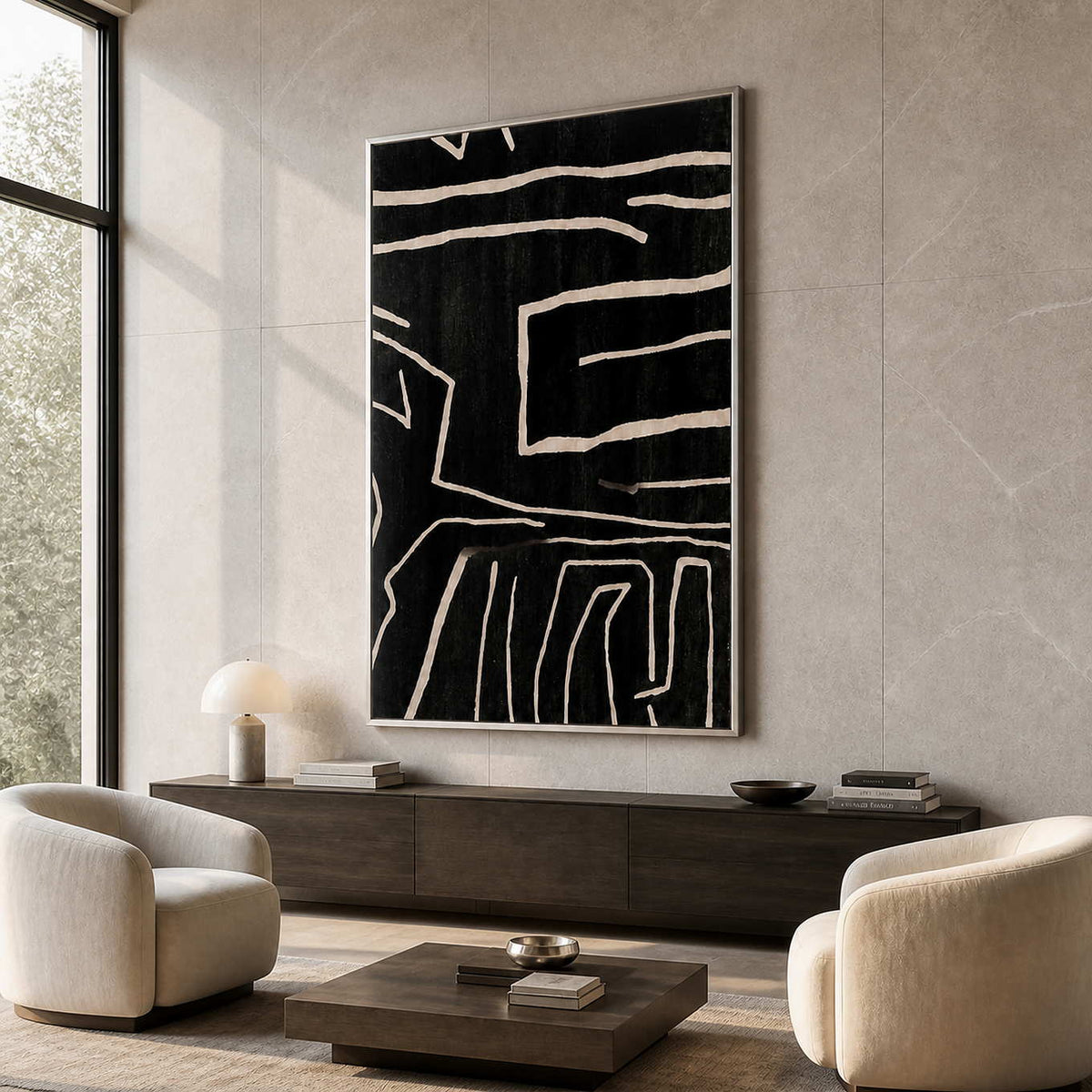 Silver framed black line artwork hangs above walnut cabinetry between cream armchairs.