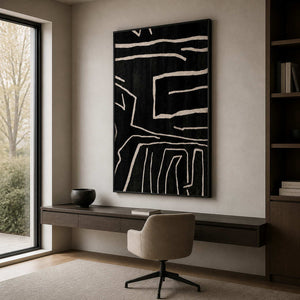 Black framed pale line artwork above a floating desk beside tall windows.